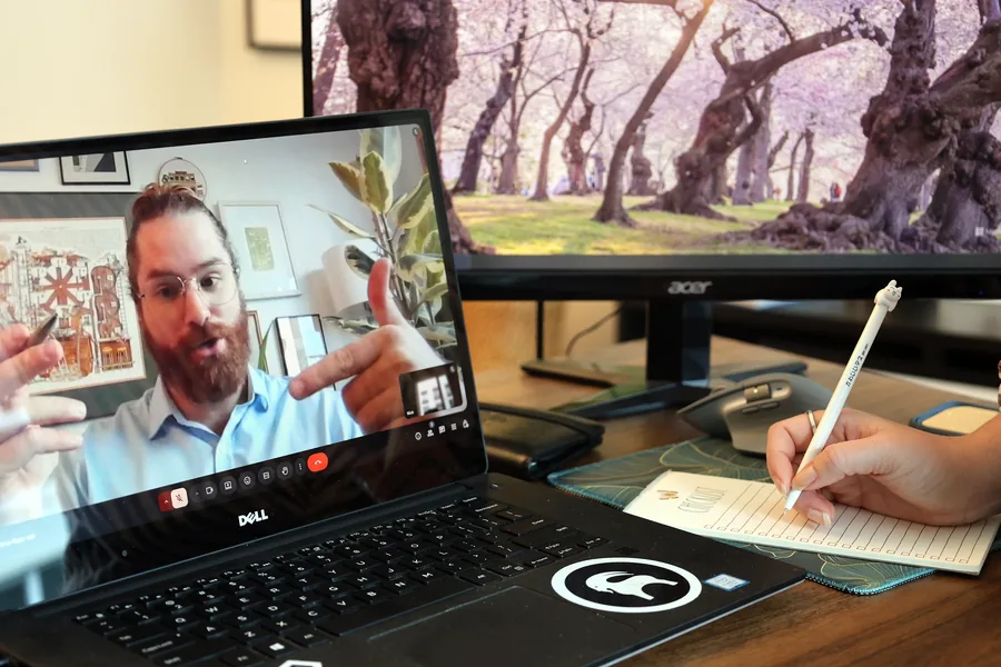 Nick walking a client through their report on a video call while they take notes