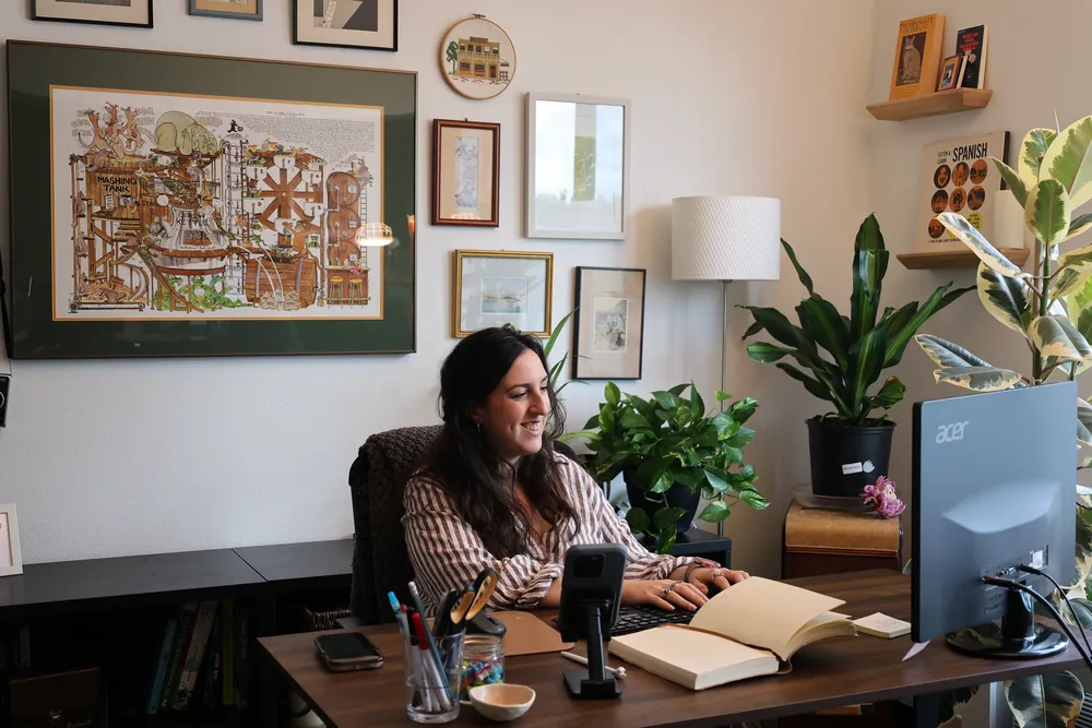 A FnButton team member answering a call and logging a new lead at her desk